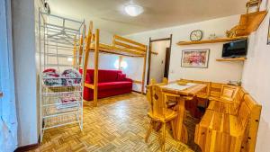 uma sala de estar com uma mesa e um beliche em Appartamento Montana - Affitti Brevi Italia em Sauze dʼOulx