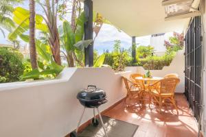 een patio met een tafel en stoelen en een grill bij Apartamento Viveros Marbella in Marbella