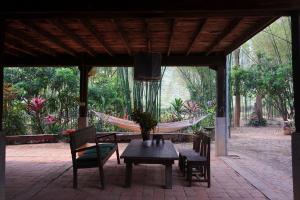 una hamaca y una mesa con sillas y una hamaca en Traditional Lanna house near hot spring, en Chiang Dao
