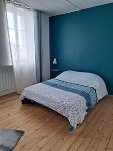 Dormitorio azul con cama y pared azul en les glycines en Saint-Marien