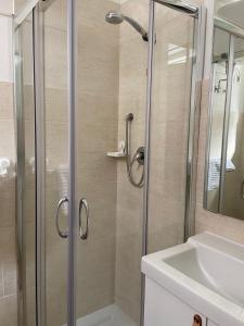 een douche met een glazen deur naast een wastafel bij Namastè monolocale in Ancona