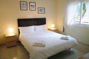 um quarto com uma grande cama branca e 2 candeeiros em Fragata em Estepona