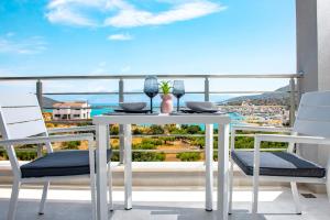 a white table and chairs on a balcony with a view at Elounda Sunshine Place in Elounda