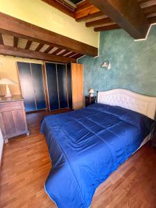 uma grande cama azul num quarto com pisos em madeira em Palazzo Collesi em Città di Castello