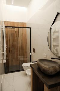 bagno con lavandino, servizi igienici e specchio di Doryana Luxury a Napoli