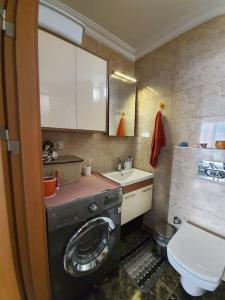 a small bathroom with a washing machine and a toilet at Cozy 3 Room Duplex With Terrace in Istanbul