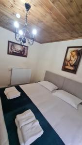 a bedroom with a large white bed with two pillows at Bujtina 31 in Korçë