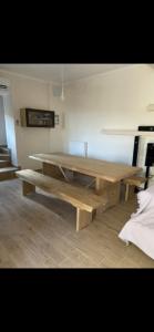 a wooden table and benches in a room at The Small Mountain house in Séta