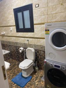 y baño con aseo y lavadora. en Poseidon Luxury Apartments, en Hurghada