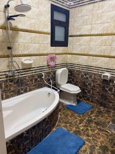 y baño con bañera y aseo. en Poseidon Luxury Apartments, en Hurghada