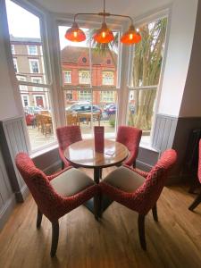 a table and chairs in a room with a window at The Post House, Llandudno in Llandudno