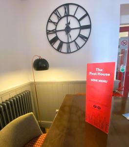 a room with a table with a clock on the wall at The Post House, Llandudno in Llandudno