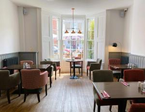 a restaurant with tables and chairs and a window at The Post House, Llandudno in Llandudno