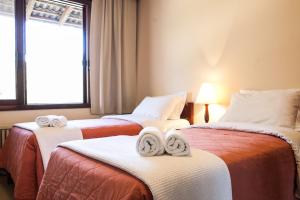 a hotel room with two beds with towels on them at Hotel Estancia Betania in Colombo +27 photos