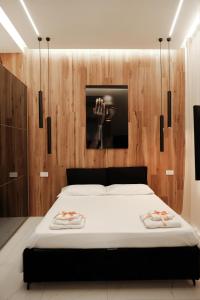 una camera con un letto bianco e una parete in legno di Doryana Luxury a Napoli
