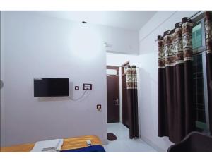 ムザッファルプルにあるHotel Modern Palace, Muzaffarpurのベッド1台と壁掛けテレビが備わる客室です。
