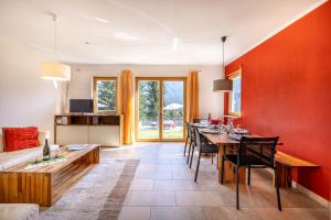 a living room with red walls and a table and chairs at Arch San Martin B in Scuol