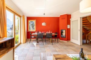 a dining room with orange walls and a table and chairs at Arch San Martin B in Scuol