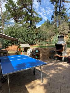 a blue ping pong table in a backyard with a grill at Can Marasí in Lloret de Mar