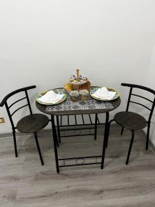 een tafel met twee stoelen en een kom eten erop bij B&B il Rio in Anacapri