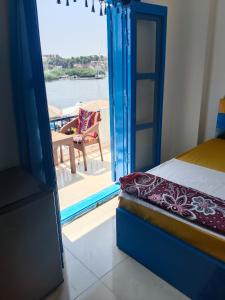 Schlafzimmer mit einem Bett und Blick auf ein Boot in der Unterkunft Airkela Nuba Dool2 in Assuan