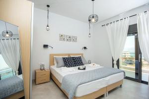 a bedroom with a bed and a large window at Elounda Sunshine Place in Elounda