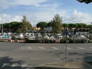 an empty street with a parking lot with cars at Residence Aprilia in Grado