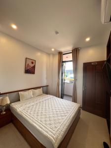 a bedroom with a bed with a white comforter at Khách sạn Phương Trinh in Pleiku