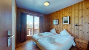 a bedroom with a large bed and a balcony at Tschoueilles 5 MOUNTAIN & QUIET chalet 10 pers in Veysonnaz