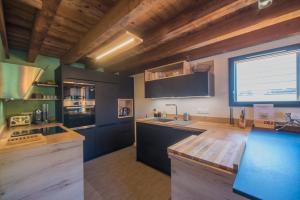 eine Küche mit schwarzen Schränken und einem großen Fenster in der Unterkunft Le Refuge des Castorres - Chalet moderne in Les Orres
