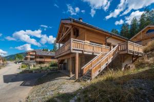 a log cabin with a staircase leading up to a house at Le Refuge des Castorres - Chalet moderne in Les Orres