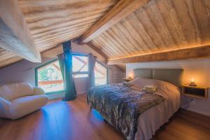 sypialnia z łóżkiem i drewnianym sufitem w obiekcie Le Refuge des Castorres - Chalet moderne w mieście Les Orres