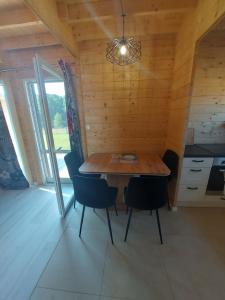 ein Esszimmer mit einem Holztisch und Stühlen in der Unterkunft Haus Zielony und Haus Czerwony 