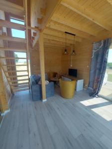 een kamer in een houten huis met een tafel en een bank bij Haus Zielony und Haus Czerwony 