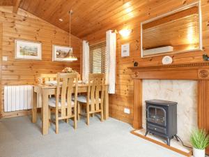 a dining room with a table and a wood stove at Ennerdale Lodge in Keswick