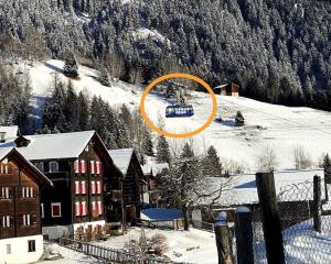 um círculo laranja num teleférico de esqui na neve em Ferienhaus Casa Pistur em Disentis