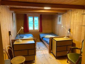 um quarto com 2 camas, uma secretária e uma janela em Ferienhaus Casa Pistur em Disentis