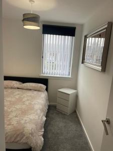 a bedroom with a bed and two windows at A glimpse of the championship in Carnoustie