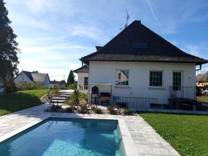 una casa con piscina frente a una casa en La Maison d'Enfance, en Heimsbrunn