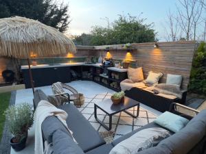 a patio with couches and a table with a bar at Rosa - Joss Bay in Kent