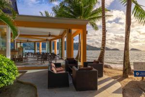 象島的住宿－Utalay Koh Chang Villas，海滩上的房子,配有椅子和棕榈树