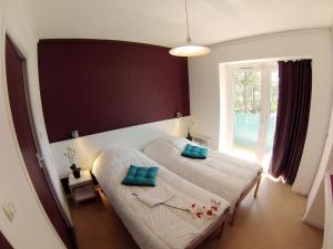 a bedroom with two beds and a large window at Village Vacances Les Dunes - Domaine de Bombannes in Carcans