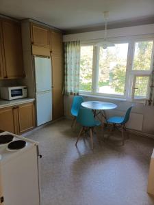 a kitchen with a table and chairs in a room at Siisti valoisa kolmio in Lieksa