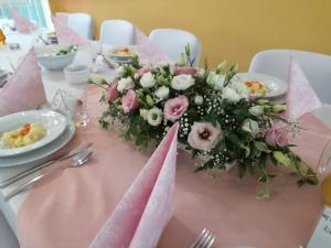 a pink table with a bouquet of flowers on it at Szczecińskie Centrum Tenisowe in Szczecin