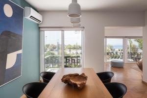 a dining room with a wooden table and chairs at Glyfada Unique Residence in Athens