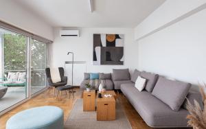 a living room with a couch and a table at Glyfada Unique Residence in Athens