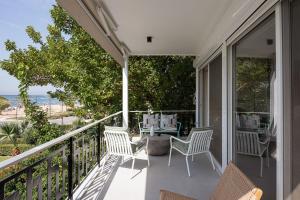 a patio with chairs and a table on a balcony at Glyfada Unique Residence in Athens