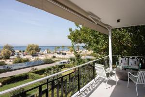 a balcony with two chairs and a view of the ocean at Glyfada Unique Residence in Athens