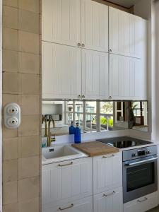 a kitchen with white cabinets and a sink at Villa La Rafale plage centre 300 m in Le Touquet-Paris-Plage