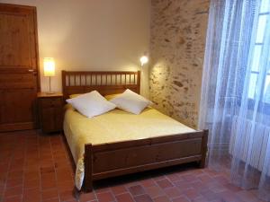 a bedroom with a bed with yellow sheets and a window at Le Clos De La Bouteille in Angers